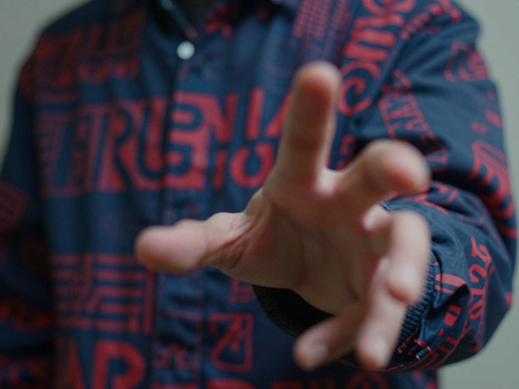 Distorted fingers and garbled text on a jacket in an image